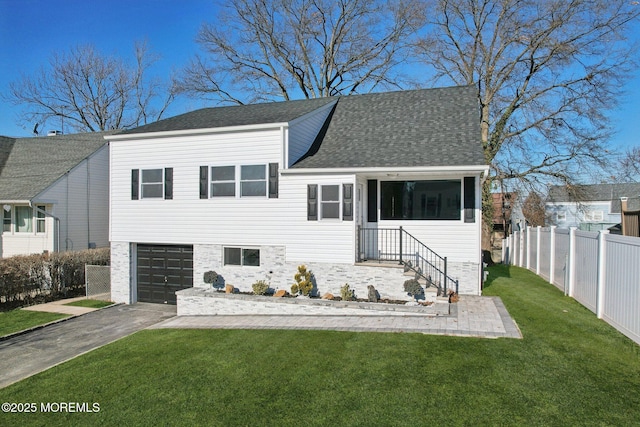 split level home with a front yard and a garage