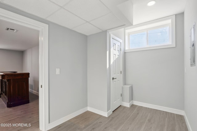 interior space featuring light wood-type flooring and a paneled ceiling