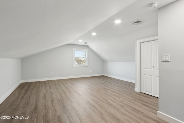 bonus room with lofted ceiling and light hardwood / wood-style floors