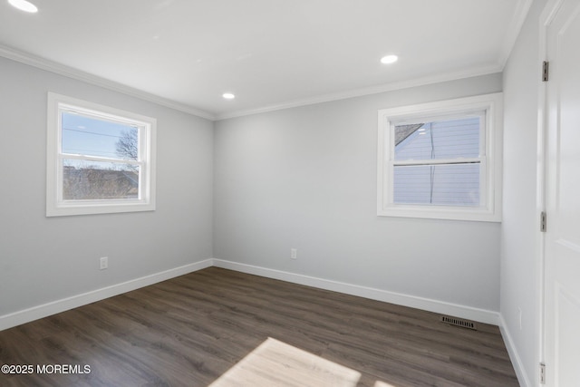 spare room featuring ornamental molding and dark hardwood / wood-style flooring