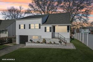 view of front facade with a yard and a garage