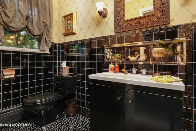 bathroom featuring vanity, toilet, and tile walls