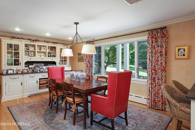 dining area featuring light hardwood / wood-style flooring, a baseboard heating unit, and ornamental molding