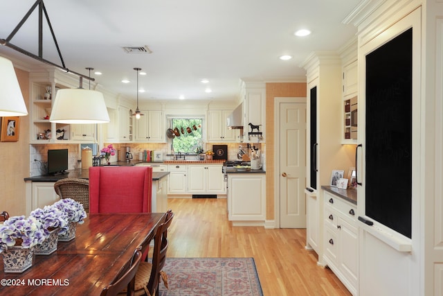 dining area featuring light hardwood / wood-style floors and ornamental molding