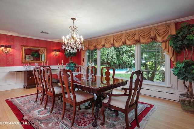 dining space with a chandelier, light hardwood / wood-style floors, baseboard heating, and ornamental molding