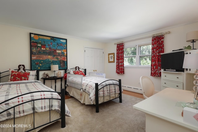 bedroom with a closet, baseboard heating, and crown molding