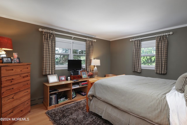 bedroom with multiple windows, hardwood / wood-style flooring, baseboard heating, and ornamental molding