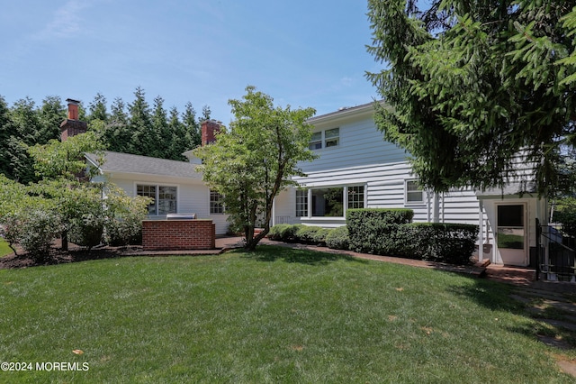 rear view of property with a lawn