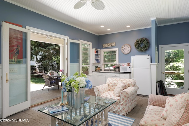 living room featuring ceiling fan, ornamental molding, and sink