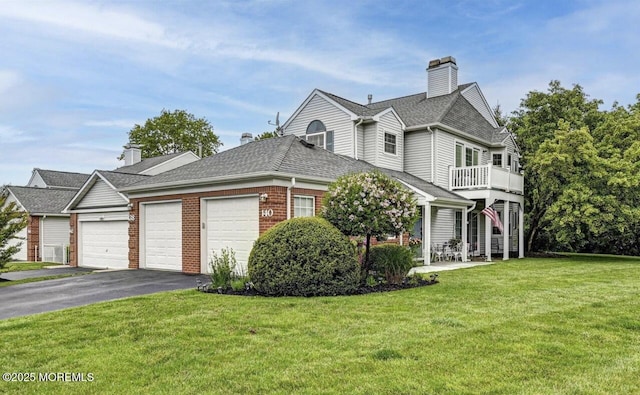 view of front of property with a balcony, a garage, and a front lawn