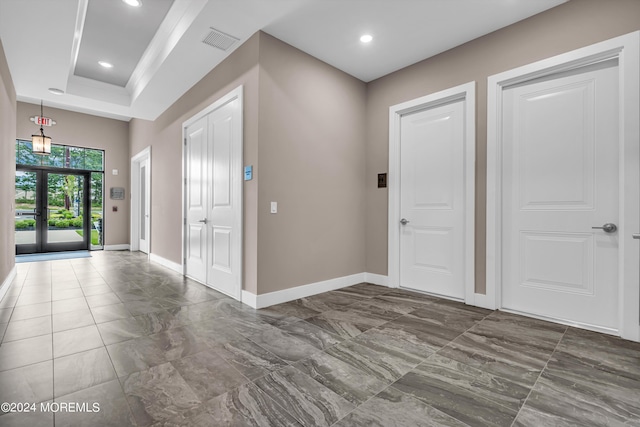 entryway with french doors and a tray ceiling