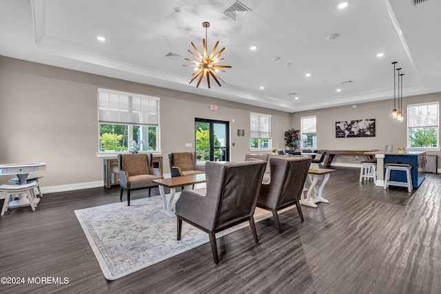 living room with dark hardwood / wood-style flooring, a tray ceiling, crown molding, and a notable chandelier