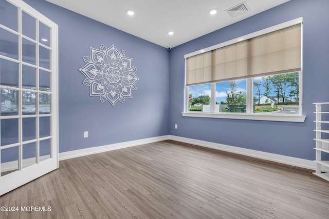 unfurnished room with a chandelier and wood-type flooring