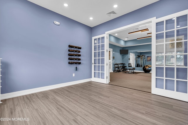 unfurnished room featuring french doors and wood-type flooring