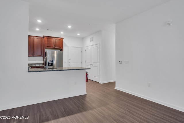 kitchen with stainless steel fridge with ice dispenser, sink, dark stone counters, and dark hardwood / wood-style floors