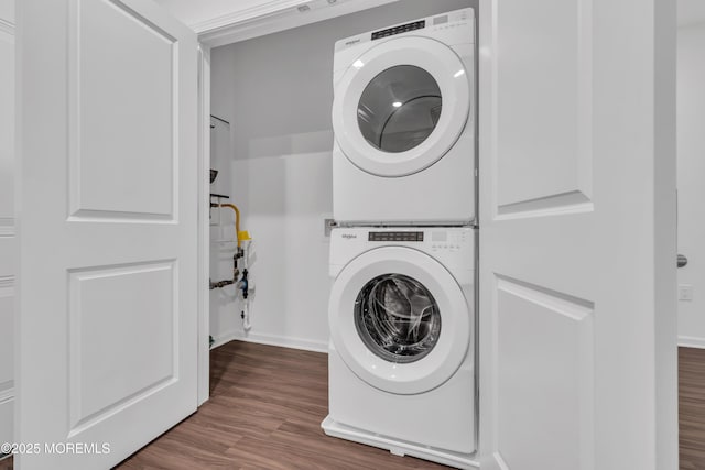 washroom with hardwood / wood-style floors and stacked washer and dryer