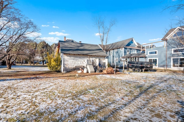 view of snow covered back of property