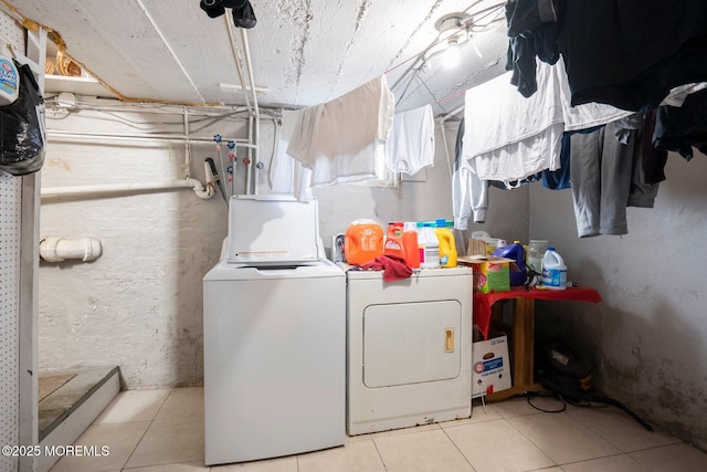 clothes washing area with light tile patterned floors and washing machine and dryer