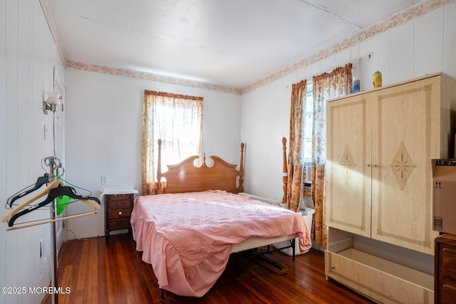 bedroom featuring dark wood-type flooring and wood walls