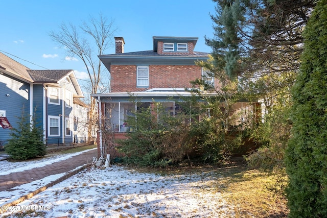 snow covered property with a sunroom