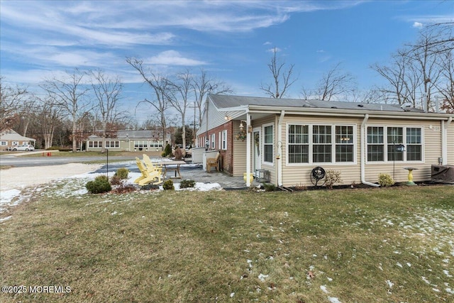 view of side of property with a lawn and cooling unit