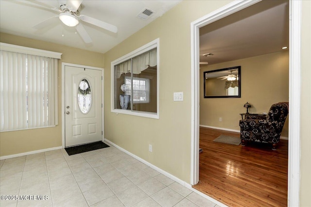 entryway featuring light tile patterned floors and ceiling fan