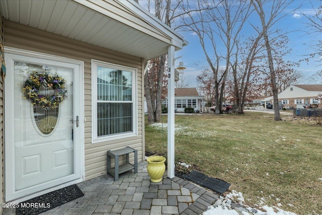 view of exterior entry with a yard