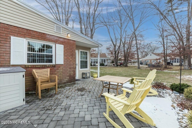 snow covered patio featuring a lawn