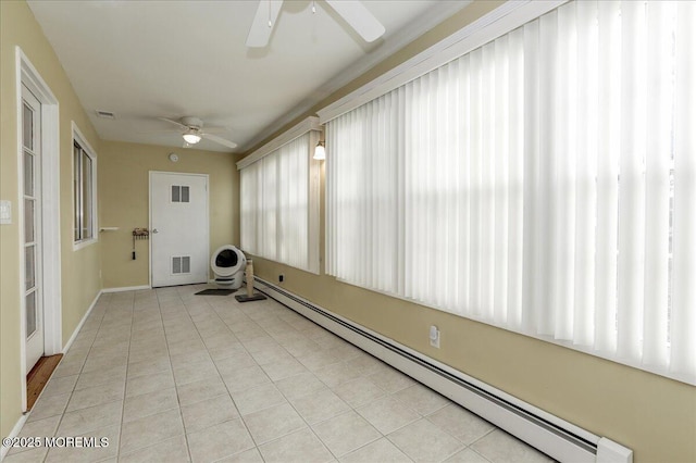 unfurnished sunroom featuring ceiling fan and a baseboard radiator