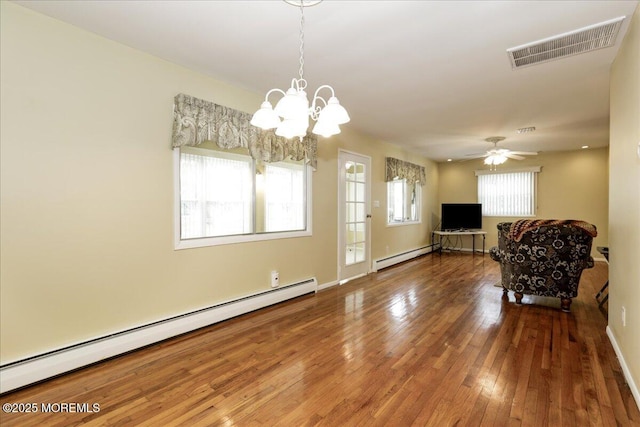 interior space with baseboard heating, ceiling fan with notable chandelier, and hardwood / wood-style flooring