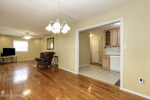 interior space featuring ceiling fan with notable chandelier and light wood-type flooring