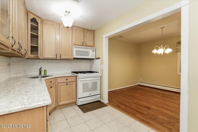 kitchen featuring white appliances, sink, light brown cabinetry, and a baseboard radiator