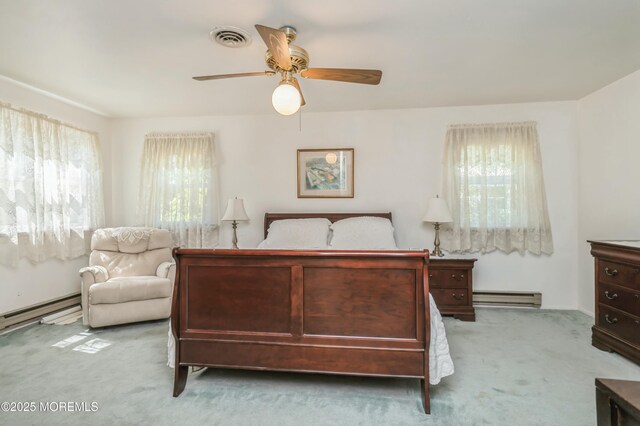 bedroom with ceiling fan, light colored carpet, and a baseboard heating unit