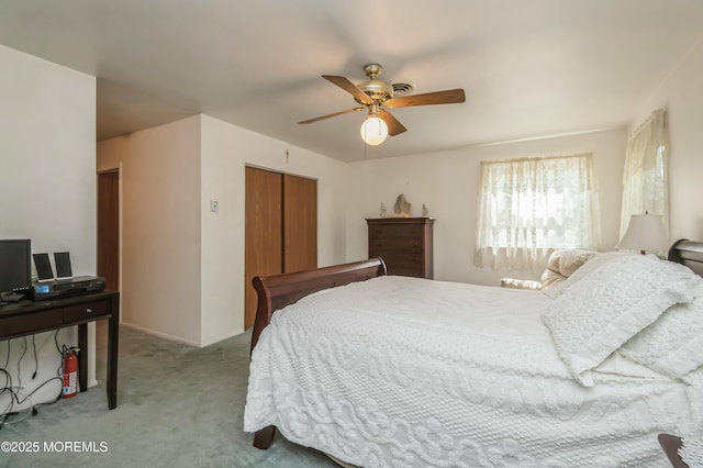 bedroom with a closet, ceiling fan, and light colored carpet