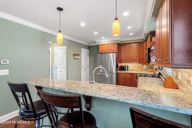 kitchen with crown molding, appliances with stainless steel finishes, kitchen peninsula, light stone countertops, and decorative backsplash