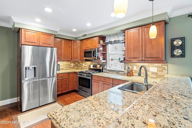 kitchen featuring sink, tasteful backsplash, decorative light fixtures, ornamental molding, and appliances with stainless steel finishes