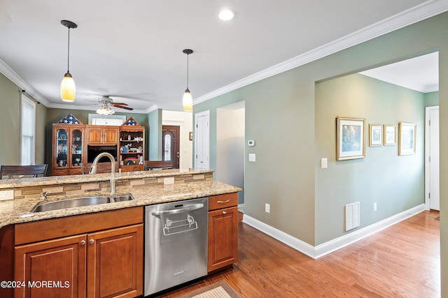 kitchen featuring hanging light fixtures, dishwasher, sink, and ornamental molding