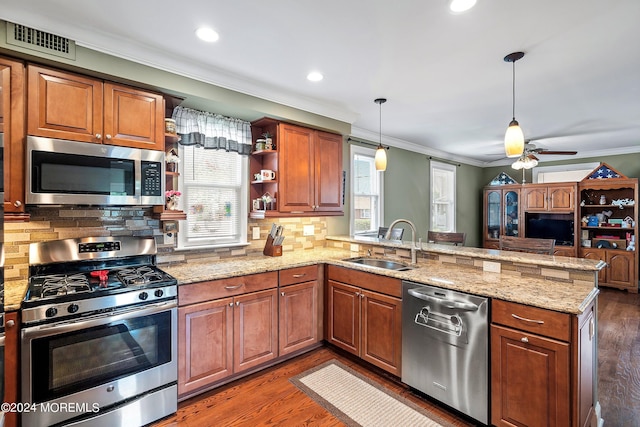 kitchen with sink, decorative backsplash, kitchen peninsula, and appliances with stainless steel finishes