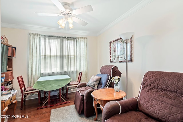 living area featuring crown molding, dark wood-type flooring, and ceiling fan