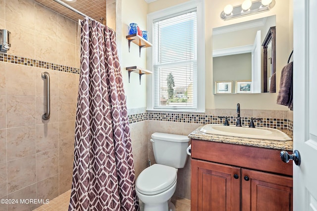 bathroom with toilet, tile walls, vanity, and a shower with curtain