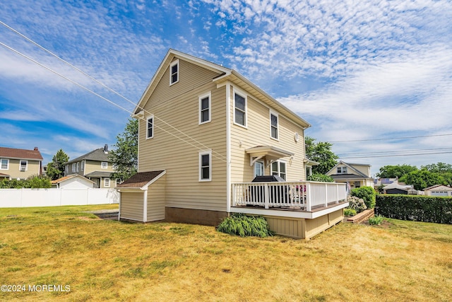 back of house featuring a wooden deck and a lawn