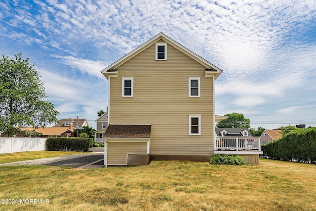 rear view of house with a yard and a deck