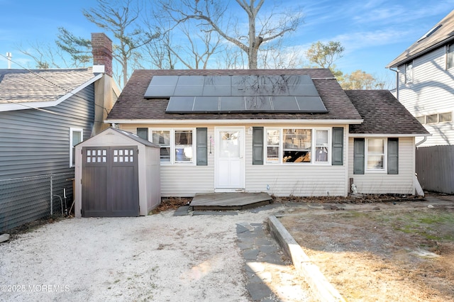 view of front facade featuring a storage shed and solar panels