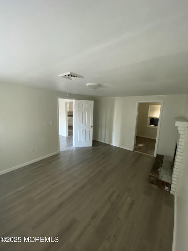 unfurnished living room with a fireplace and dark hardwood / wood-style floors