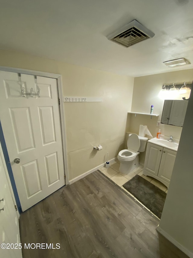 bathroom featuring vanity, hardwood / wood-style flooring, and toilet