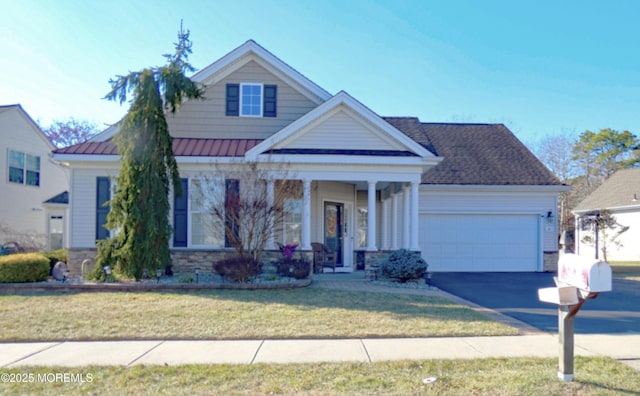 view of front of property featuring a porch, a garage, and a front yard