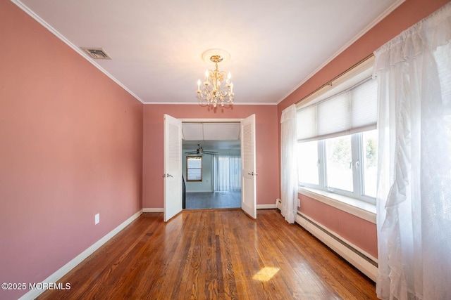 interior space with a notable chandelier, crown molding, dark wood-type flooring, and baseboard heating