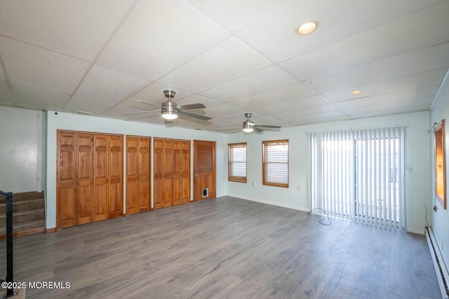 interior space featuring hardwood / wood-style flooring, a paneled ceiling, and baseboard heating