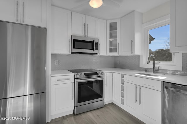 kitchen featuring backsplash, white cabinetry, sink, and stainless steel appliances