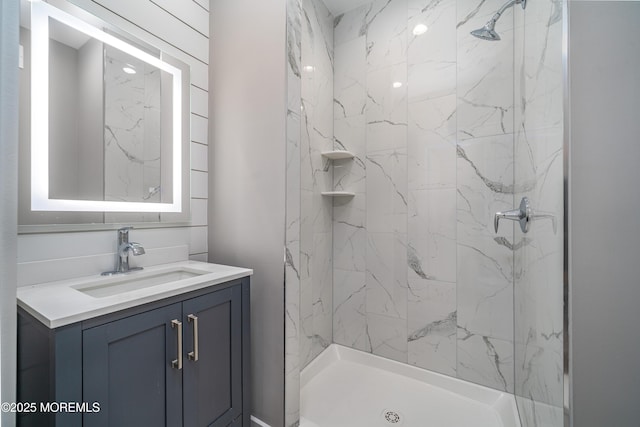 bathroom with a marble finish shower and vanity